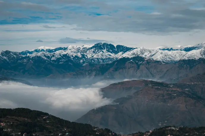 snow covered mountains under cloudy sky during daytime