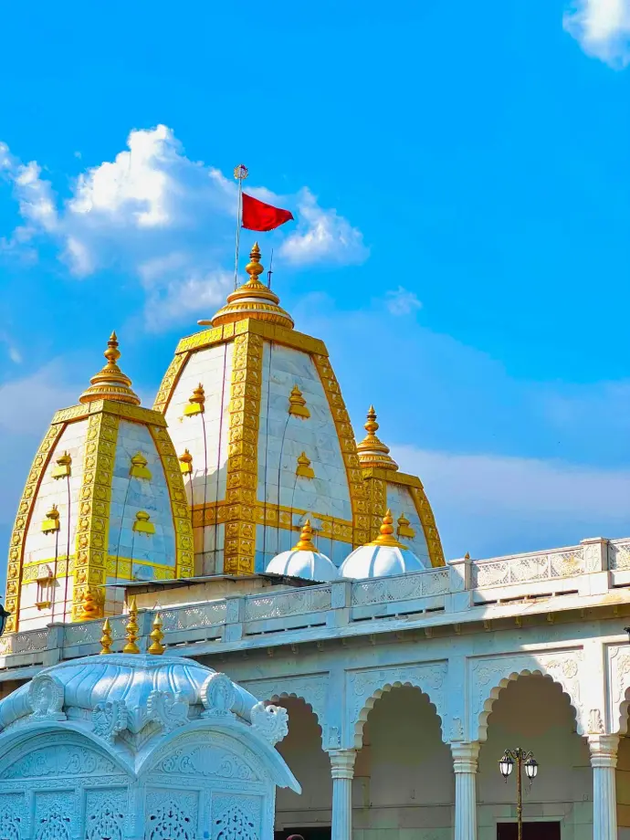 a white and gold building with a red flag on top
